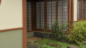 Ein traditionelles japanisches Gebäude mit Holzrahmenfenster und einem kleinen Garten mit Steinen und Pflanzen.