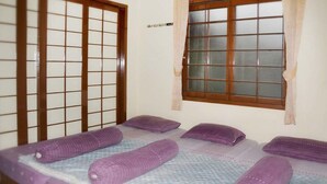 A room with a bed, a window with a view, and a door with a grid pattern. - VILLA ADE - 0224 KOTA BUNGA PUNCAK (Cipanas)