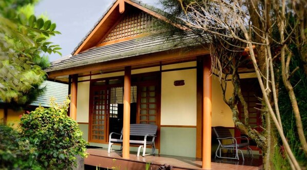 A traditional Japanese-style building with a covered porch, wooden pillars, and a tiled roof.