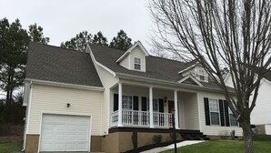 A two-story house with a front porch, a garage, and a small front yard. - House near Lee University (Cleveland)
