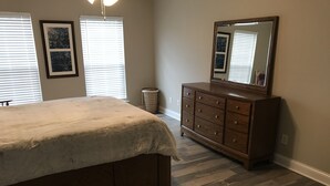 A bedroom with a bed, dresser, and mirror. - House near Lee University (Cleveland)
