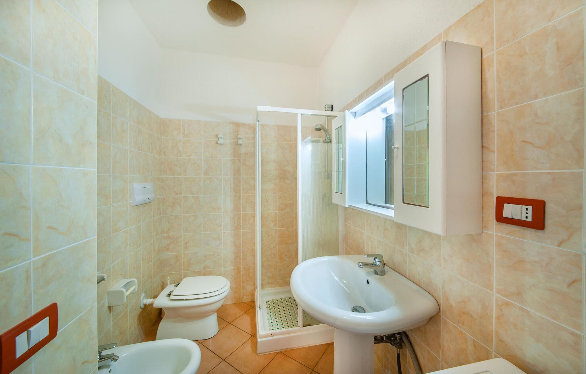 A bathroom with a toilet, bidet, and sink.