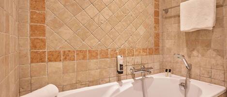 A bathroom with a bathtub, a towel rack, and a soap dispenser.