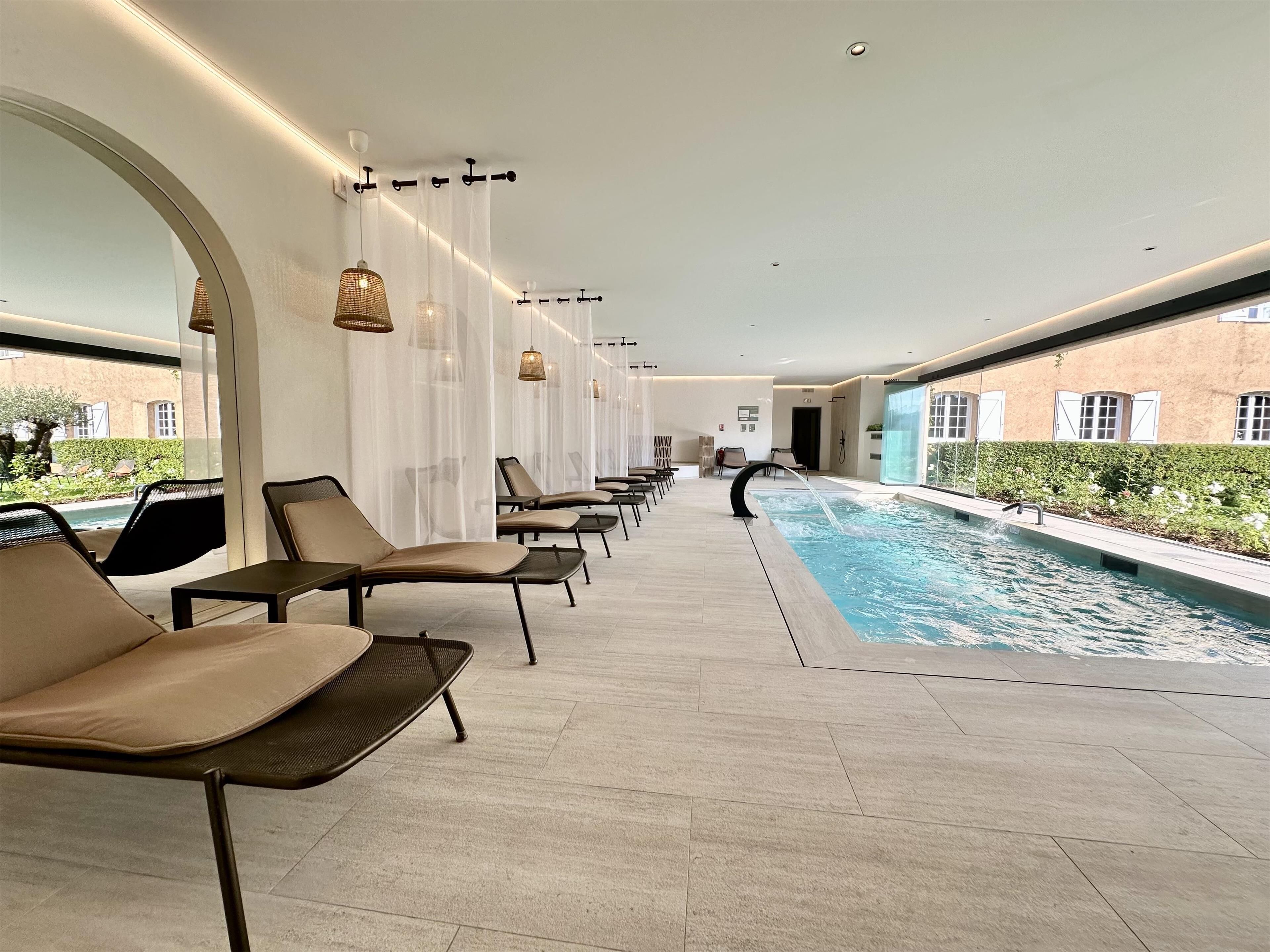 Un espace aménagé au bord de la piscine, avec des chaises longues et une piscine.