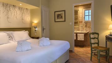 Una habitación de hotel con una cama grande, un baño con ventana y una silla.