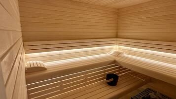 Una sauna con listelli di legno, una panca e un piccolo ripiano.