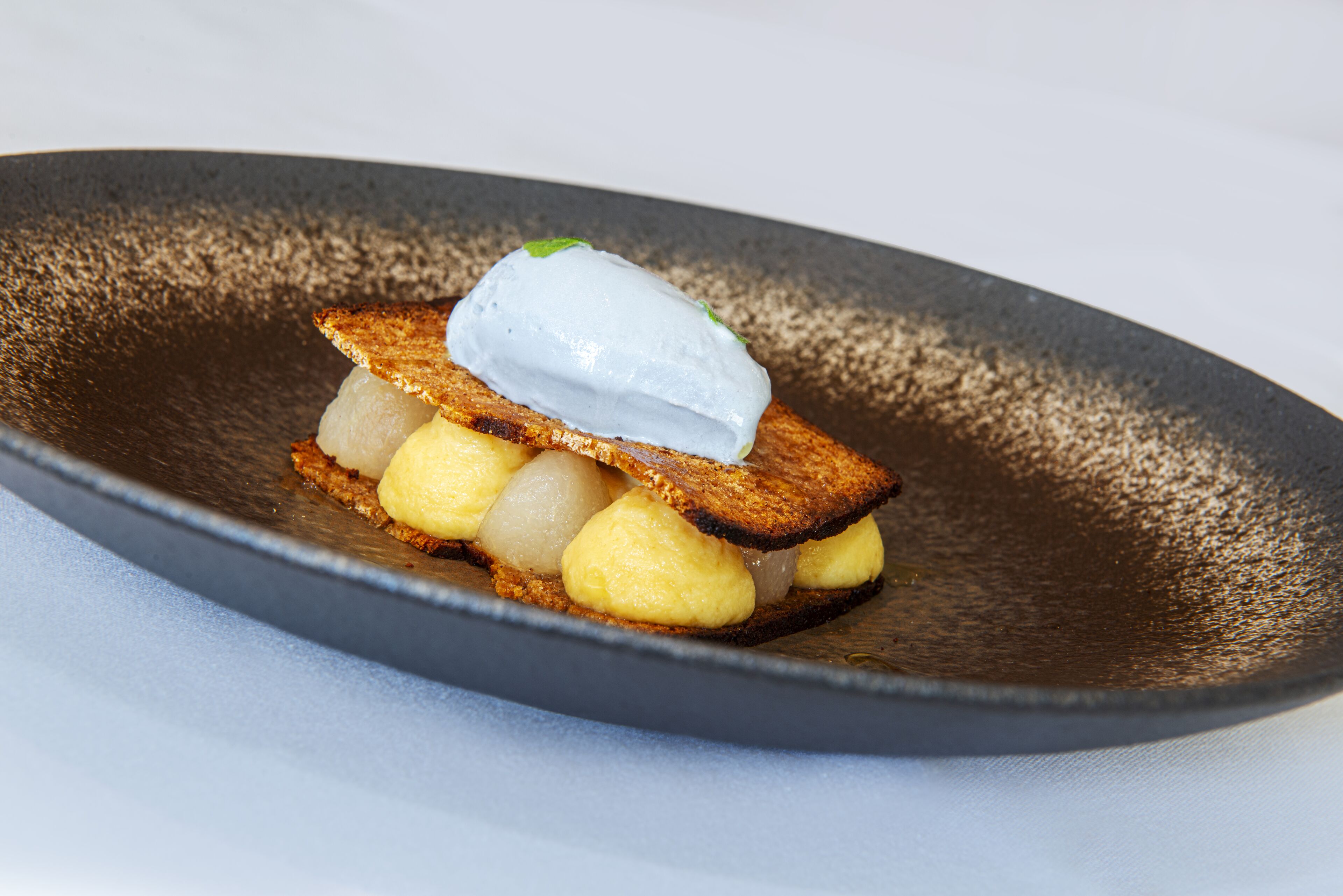 Un dessert servi dans une assiette sombre.