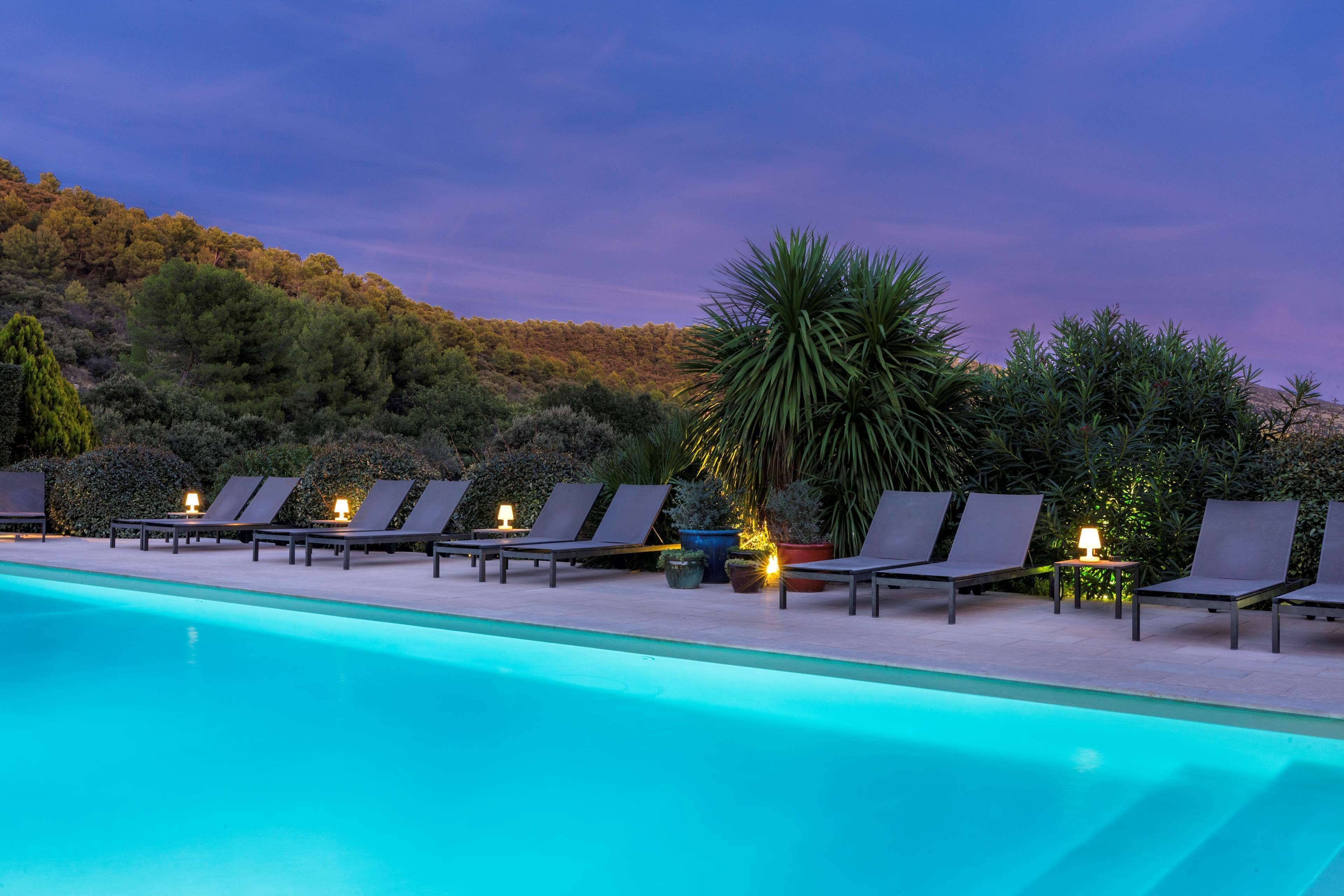 A poolside area with lounge chairs and potted plants.