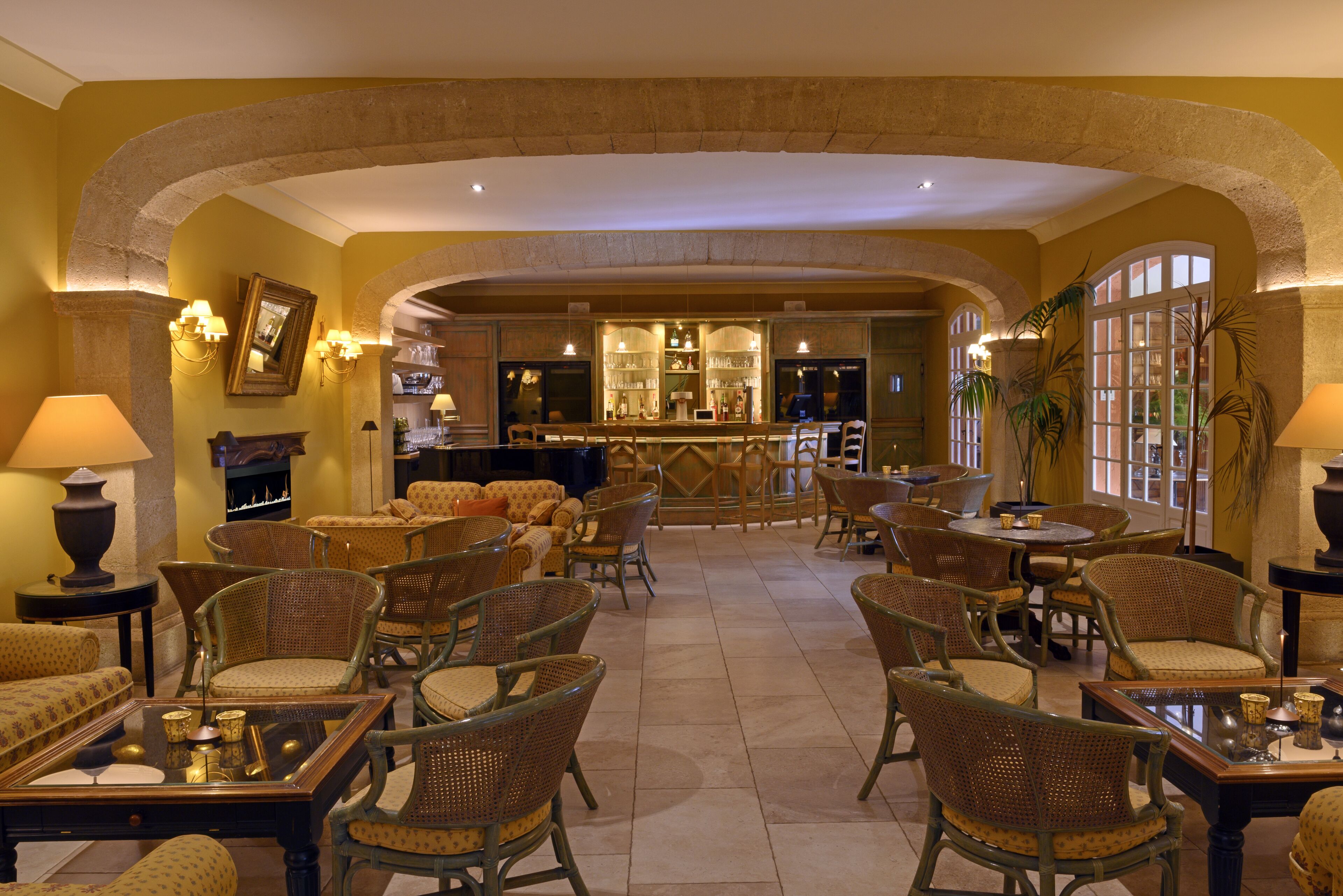 A spacious lobby with multiple seating areas, a bar, and a fireplace.