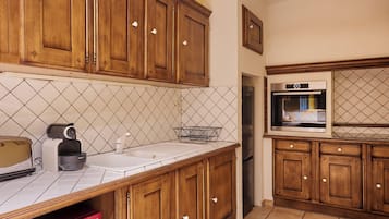 Une cuisine avec des meubles en bois, un réfrigérateur en acier inoxydable et un four à micro-ondes.