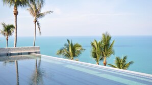 An infinity pool with clear water, palm trees, and a view of the ocean. - Kapuhala (Koh Samui)