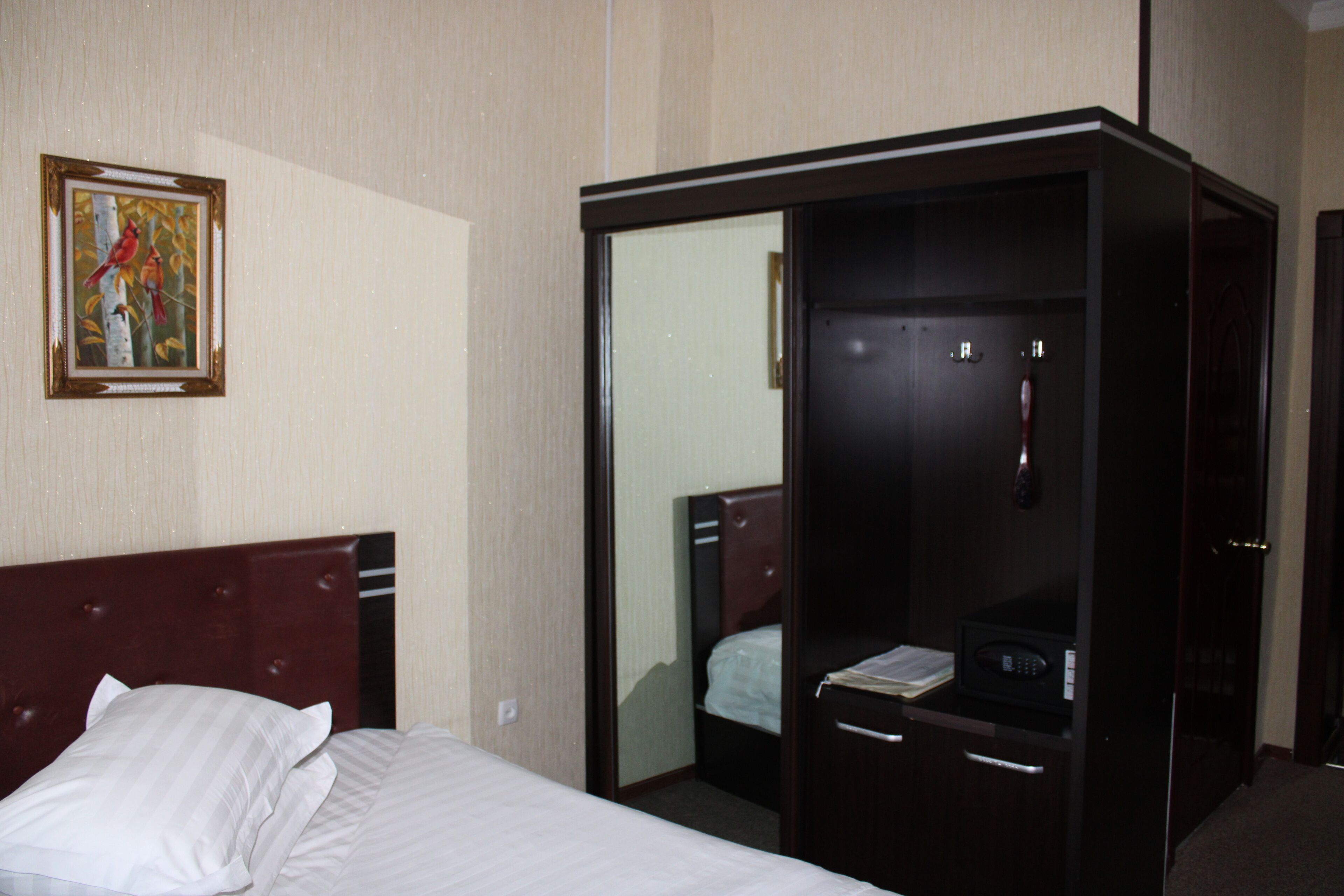Una habitación de hotel con cama, armario y espejo.
