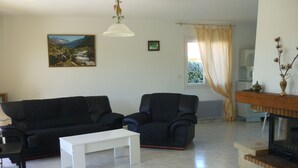 Ein Wohnzimmer mit einer schwarzen Couch, einem weißen Couchtisch und einem Kamin.
