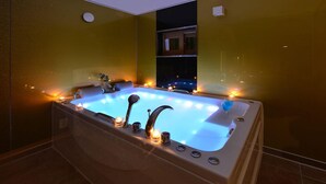 A hot tub with lights and candles, surrounded by yellow walls and a tiled floor. - Camel Pension (Gapyeong)