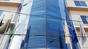 A building with a glass facade and a red sign with white text. - Richmart Resthouse (Barisal)