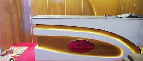 A reception desk with a sign that reads "Rich Mall Rest House Reception".