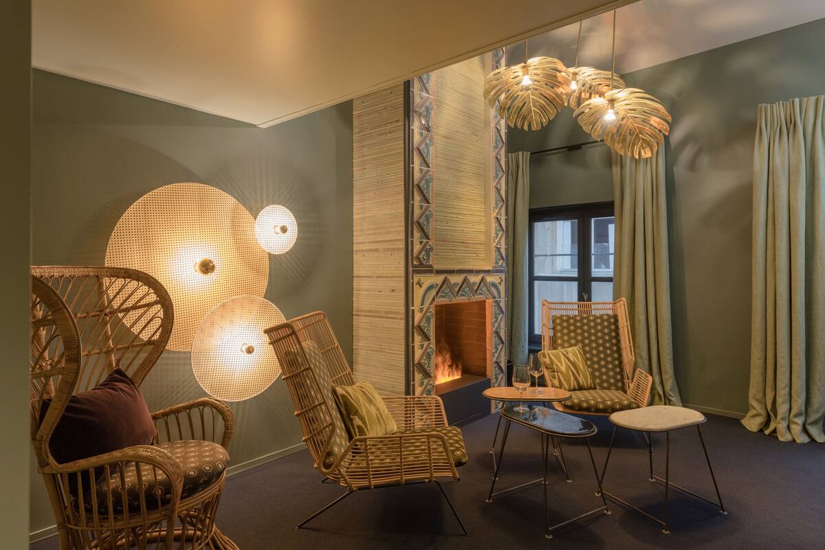 A cozy room with wicker chairs, a small round table, and a fireplace.