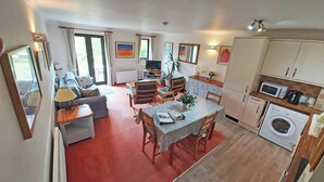 A compact living space with a dining area, kitchen, and a sofa in the living room.
