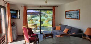 Un soggiorno con un divano, poltrone, un tavolo e una televisione.