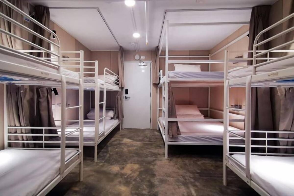 A room with bunk beds, a door, and a light fixture.