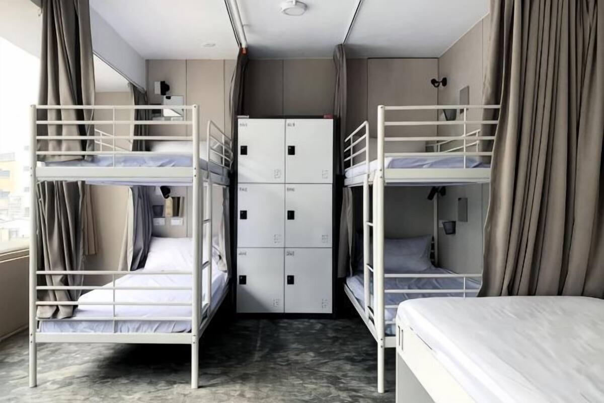 A room with bunk beds, a wardrobe, and a window with curtains.