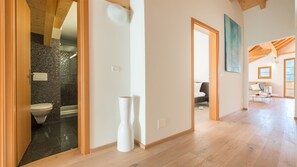 Un amplio salón con suelo de madera, un ventanal y vistas al exterior.