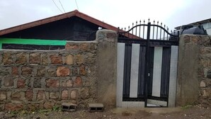 A gated entrance with a stone wall and a metal gate. - Abrham Lalibela Home Stay (Lalibela)