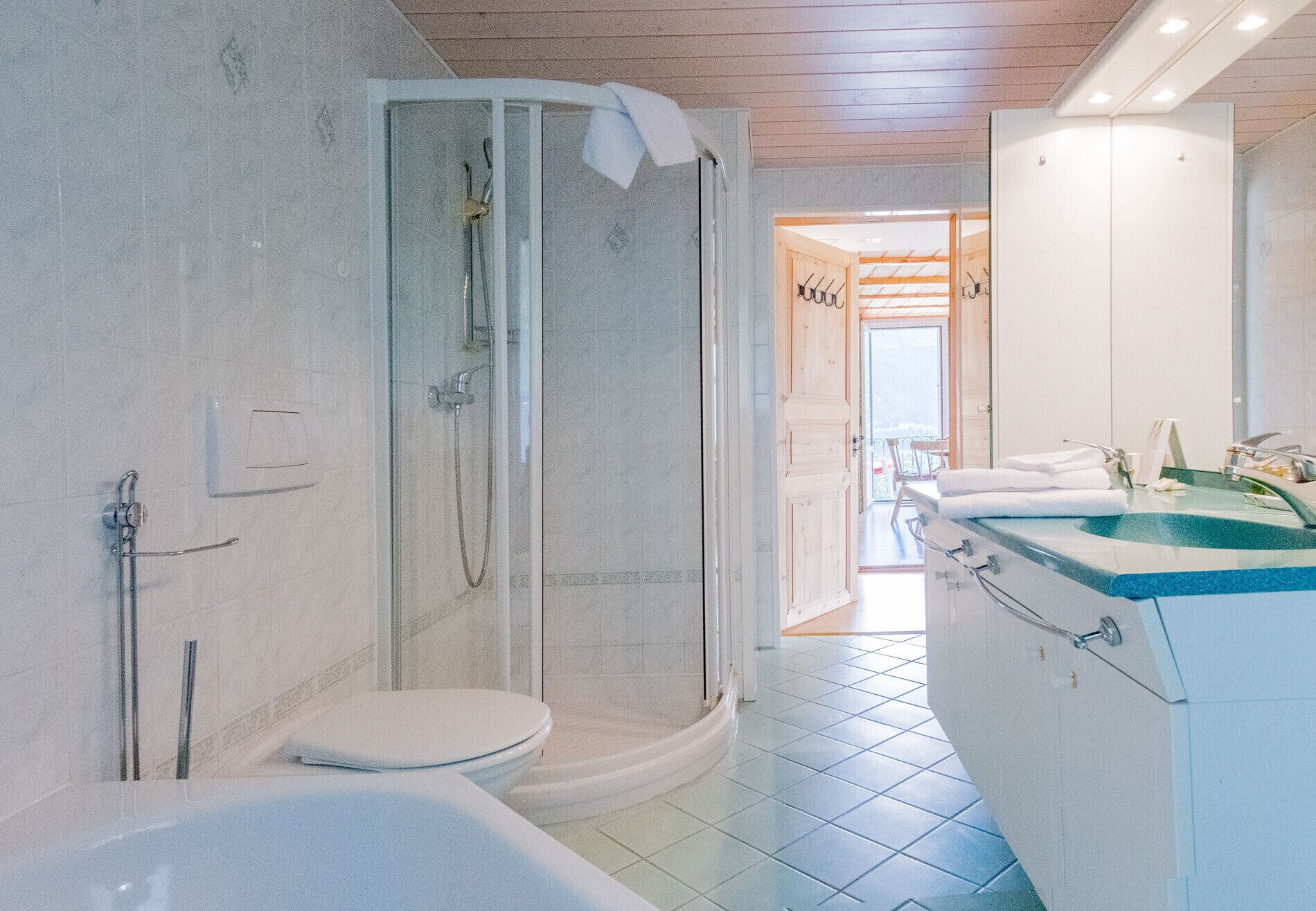 A modern bathroom with a glass-enclosed shower, a white toilet, and a sink with a blue countertop.
