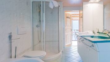 A modern bathroom with a glass-enclosed shower, a white toilet, and a sink with a blue countertop.