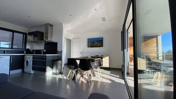 Una cocina moderna con comedor, ventanas amplias y vistas al exterior.