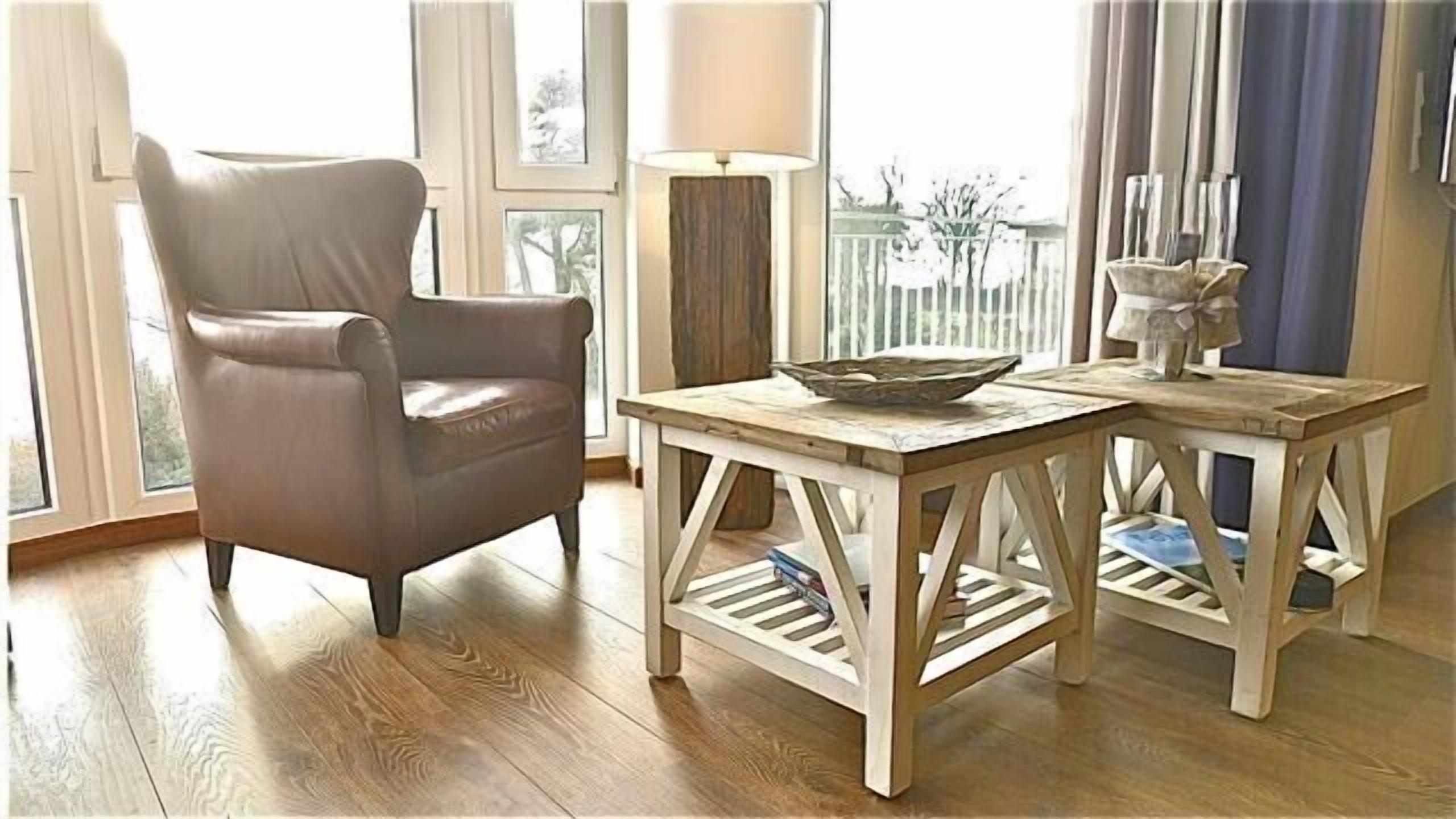 Ein Zimmer mit Ledersessel, Holztisch und einer Schale sowie einer Lampe.