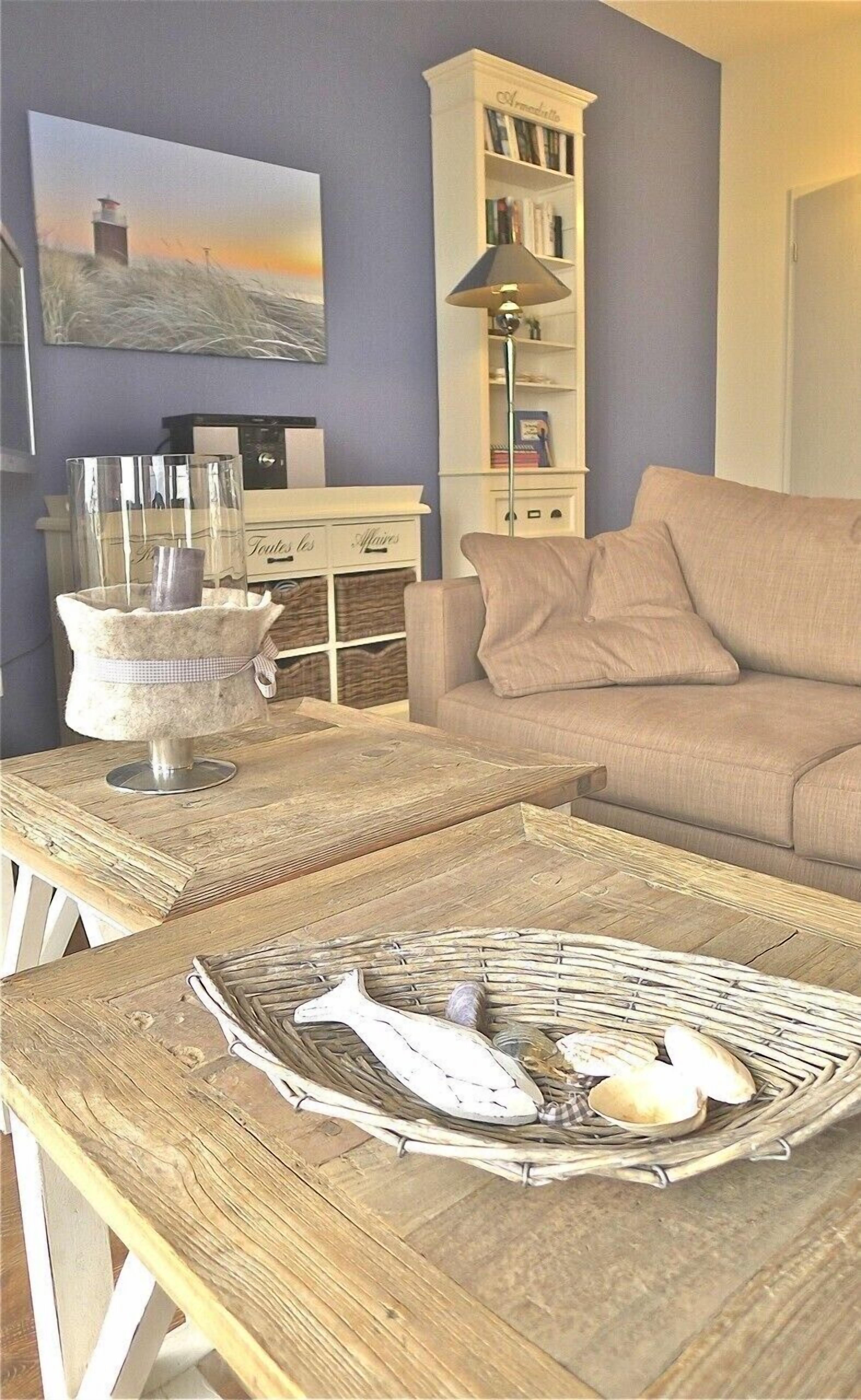Ein Wohnzimmer mit einer Couch, einem Couchtisch mit einer dekorativen Ablage, einer Lampe und einem Bücherregal.