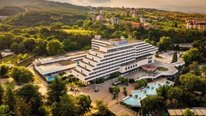 A modern hotel with multiple floors, a central courtyard, and several swimming pools. - Interhotel Sandanski (Sandanski)