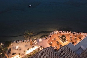 Enjoy breathtaking views of the water from this rooftop terrace, featuring comfortable seating areas and ambient lighting.