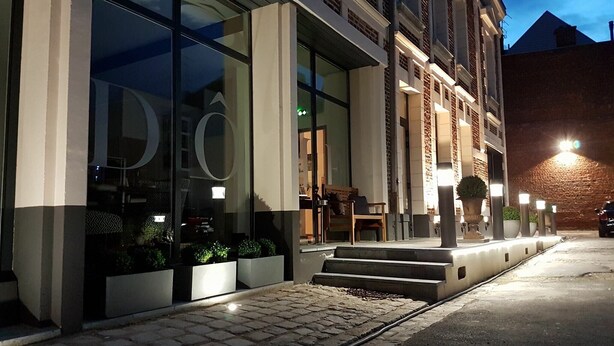 A modern building with large glass windows and a brick facade. - Hotel Le Dome (Arras)