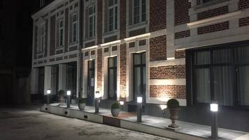 En bygning med flere etager, murstensfacade og store vinduer.