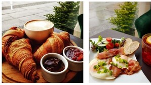 A breakfast setting with croissants, coffee, and a plate of smoked salmon with vegetables. - DUKES Apartments - Old Town (Wroclaw)