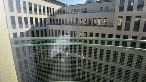 En byggnad med flera våningar och en modern arkitektonisk design, med balkonger och stora fönster.