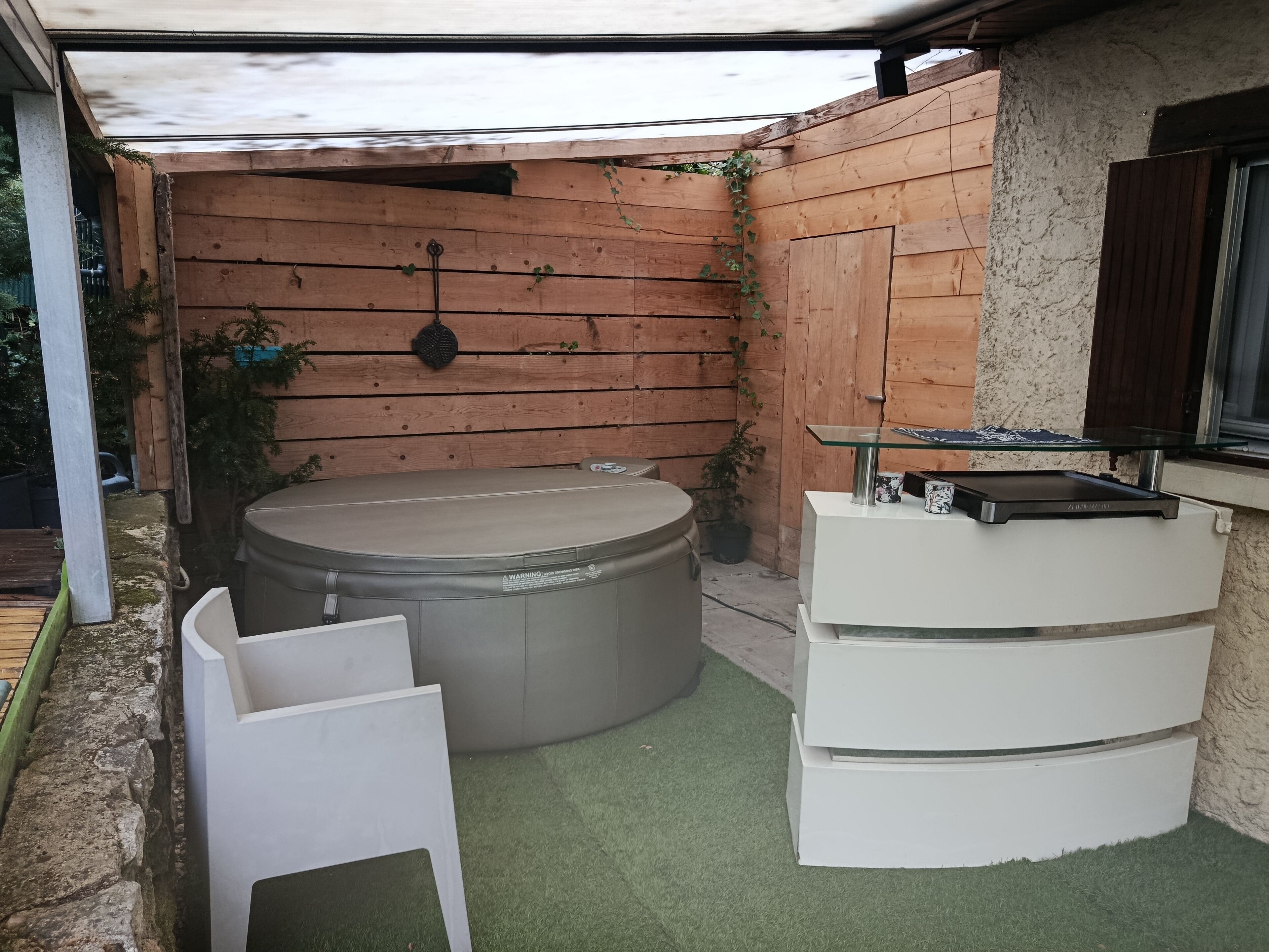 A spa area with a hot tub, a massage table, and a small table with a glass top.