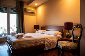 Relax in a cozy space with a comfortable bed, nightstand, and chair, perfect for unwinding.