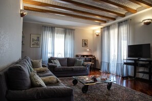 Relax in this inviting living room with a sofa, flat-screen TV, and decorative touches.