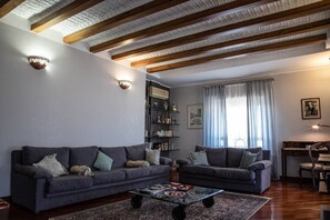 Relax in this stylish living room with a high ceiling, sofas, coffee table, and bookshelf.