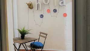 Ein kleiner Patio-Bereich mit Tisch und Stuhl, einem Blumentopf und einer Wand, auf der das Wort 