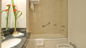 Een badkamer met een wastafel, spiegel en douche.