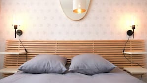 A bedroom with a wooden slat headboard, two bedside tables, and two wall-mounted lamps. - ★★ Le Grand Chambord ★★ (Laval)