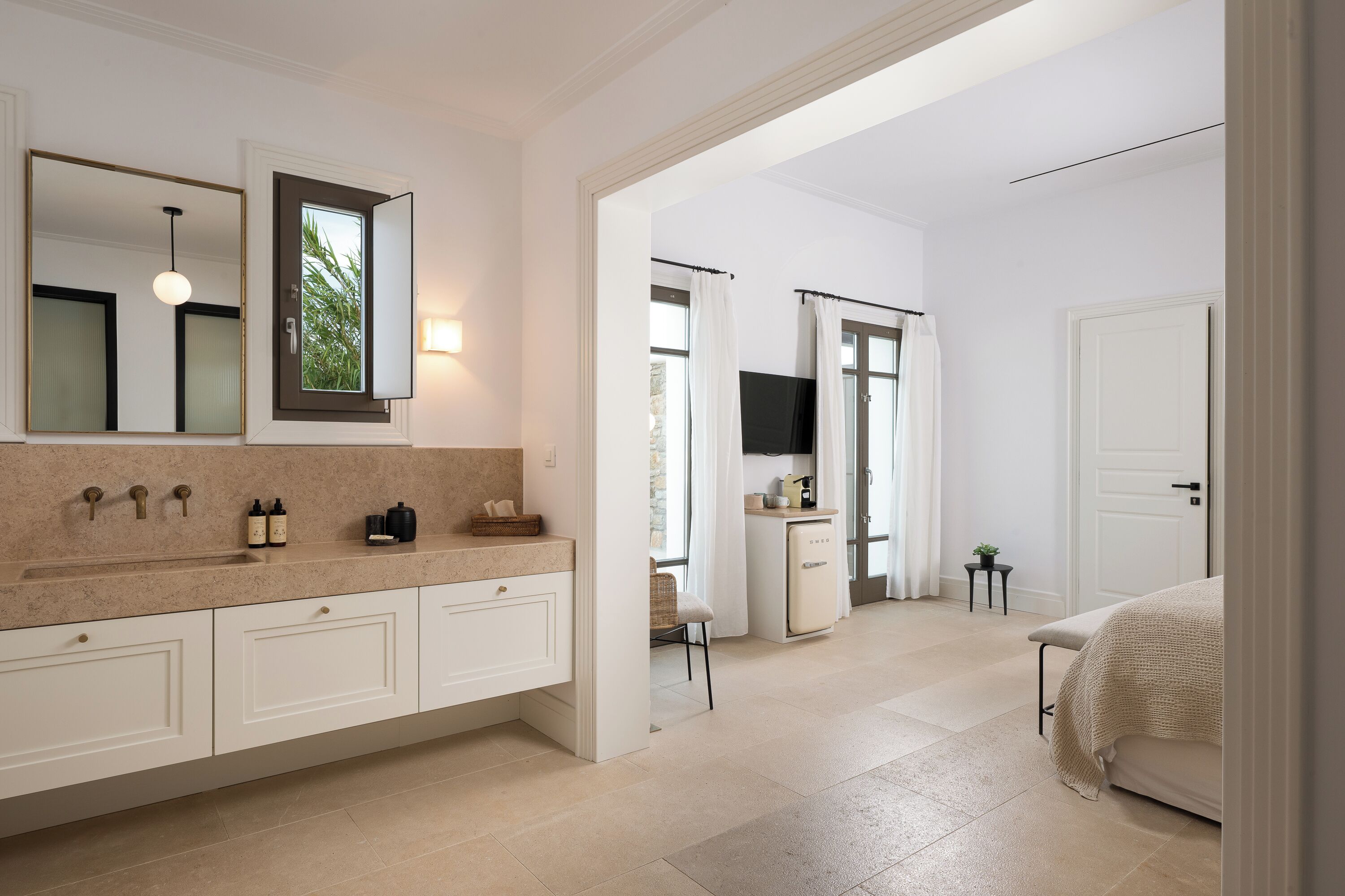 Une salle de bain moderne avec un grand miroir, un meuble-lavabo doté d’un plan de travail et un espace douche.