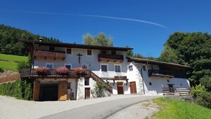 A two-story building with a balcony, a staircase, and a small tower-like structure. - Agriturismo Gfaderhof Ferienwohnungen (Bressanone)