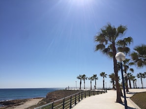 A coastal walkway with palm trees and a clear sky. - Entire House - Walk to beach, bars and restaurants! (Orihuela Costa)