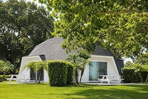 A modern house with a sloped roof, large windows, and a well-maintained lawn.