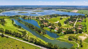 An aerial view of a golf course with multiple water bodies, surrounded by residential areas and greenery. - STUDIO 02 - Lake Sumner (Clermont)